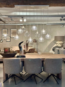 Eetkamerstoel Alma in karamelkleurige Bouclé stof met zwarte metalen draaipoot