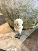 Geluksbeeldje van steen op zwart metalen voetje