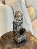 Gelukspopje hurkend van hout