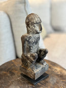 Gelukspopje hurkend van hout