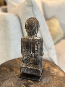 Gelukspopje hurkend van hout