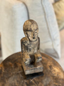 Gelukspopje hurkend van hout