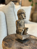 Gelukspopje hurkend van hout