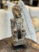 Gelukspopje hurkend van hout