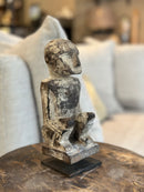 Gelukspopje hurkend van hout