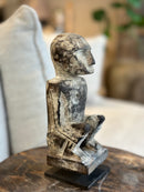 Gelukspopje hurkend van hout