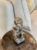 Gelukspopje hurkend van hout